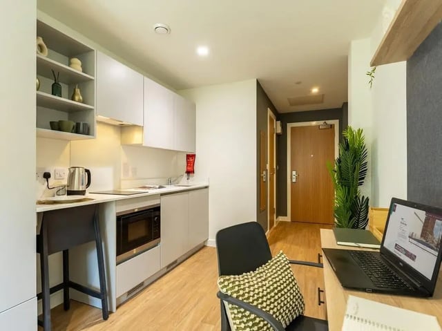 Kitchenette with microwave sink and laptop study area at Straits Aire in Leeds Student Accommodation