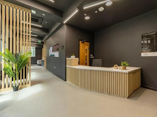Reception desk plant wooden partition hallway reception at Straits Aire in Leeds Student Accommodation