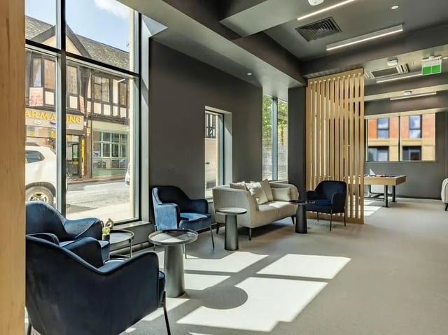 Blue chairs light sofa foosball table common area at Straits Aire in Leeds Student Accommodation