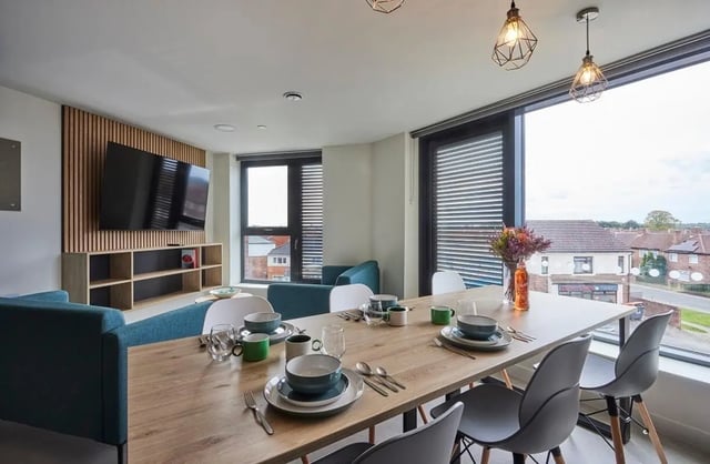 Dining table set for meal with seating area Living room at Regatta Place in Durham Student Accommodation