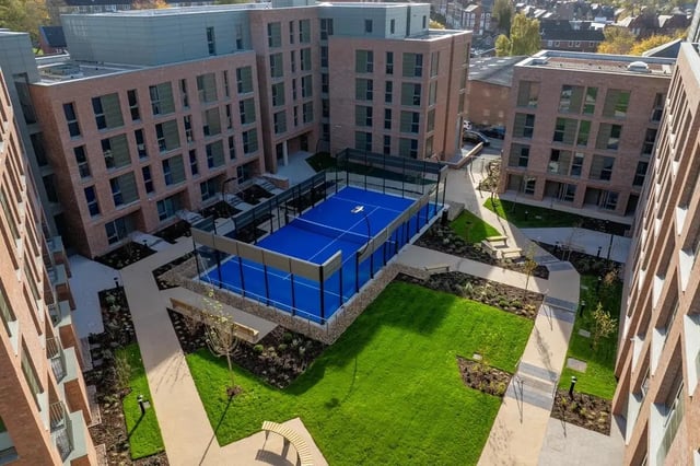 Blue padel court green lawn benches exterior at Centre Court in Nottingham Student Accommodation