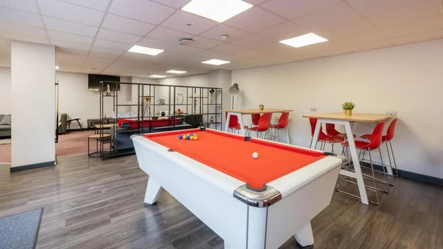 Pool table, tables, chairs, shelving, living room at Marland House in Southampton Student Accommodation