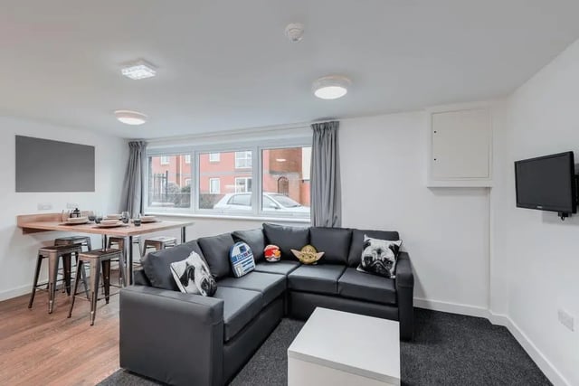 Dark sofa dining area with stools and TV living room at The Old Dairy in Plymouth Student Accommodation