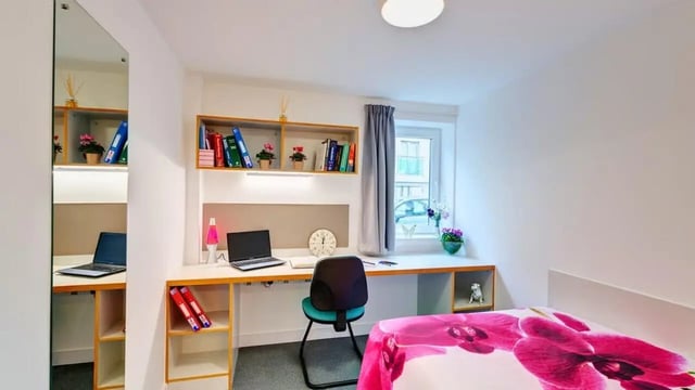 Desk with laptop bookshelves mirror and bed Bedroom at The Old Dairy in Plymouth Student Accommodation