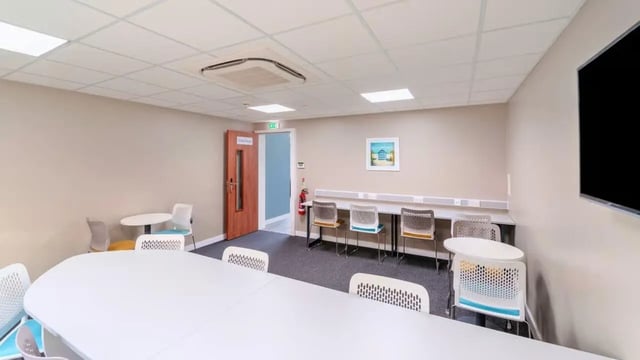 Large table chairs fire extinguisher artwork meeting room at The Old Dairy in Plymouth Student Accommodation
