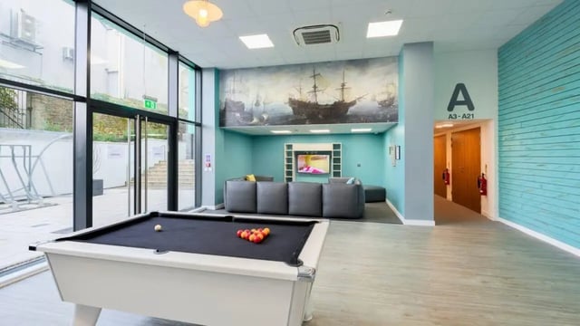 Pool table with balls and sofa area living room at The Old Dairy in Plymouth Student Accommodation
