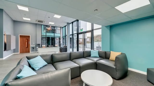 Grey sectional sofa white coffee table living area at The Old Dairy in Plymouth Student Accommodation