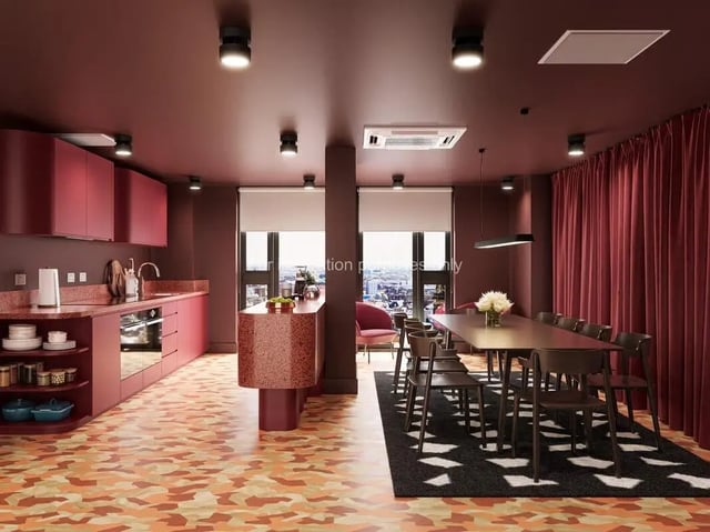 Modern kitchen and dining area with red cabinets and table at St Vincent Studios in Glasgow Student Accommodation