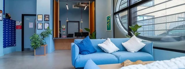 Blue sofa with cushions mailboxes and reception area at Element Manchester in Manchester Student Accommodation