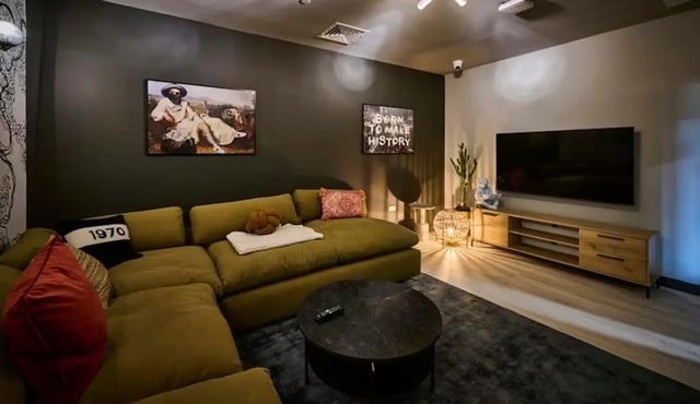 Large sectional sofa coffee table artwork and TV living room at Deakins Place in Nottingham Student Accommodation