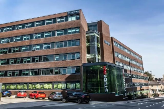 Red brick building with glass entrance cars exterior at Study Inn Talbot Street Nottingham in Nottingham Student Accommodation