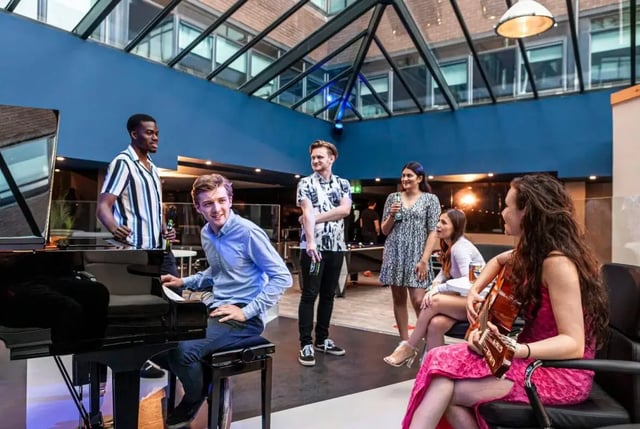 Students playing piano and guitar common area at Study Inn Talbot Street Nottingham in Nottingham Student Accommodation