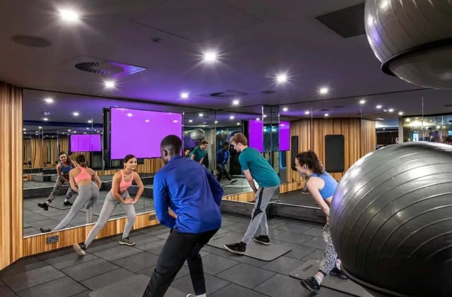 Group exercising in a gym with large mirrors playing area. at Study Inn Talbot Street Nottingham in Nottingham Student Accommodation