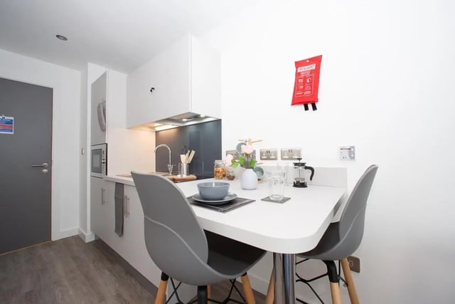 Compact kitchen with table chairs and fire blanket kitchen at The Laceworks Nottingham in Nottingham Student Accommodation