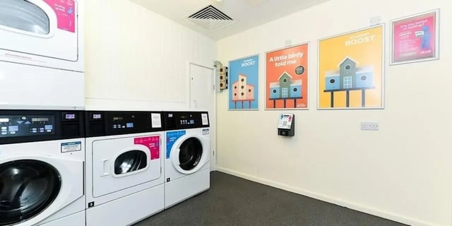 Washing machines dryers payment station posters laundry room at Laycock Studios in Sheffield Student Accommodation