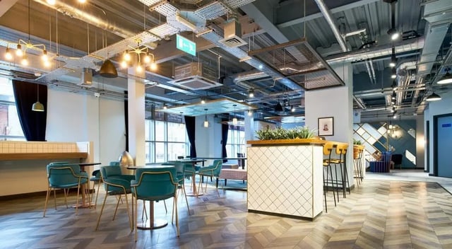 Modern communal space with teal chairs and bar area living room at Crown House in Sheffield Student Accommodation