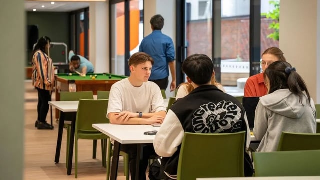 Students playing pool and sitting at tables communal area at UniLodge Auckland Central in Auckland Student Accommodation