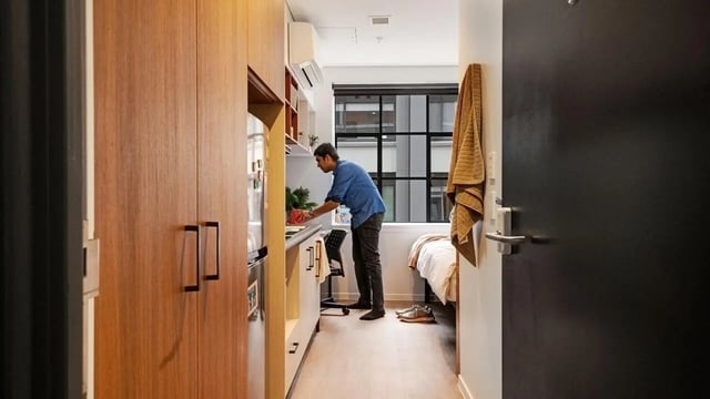 Student preparing food in studio apartment bedroom at UniLodge Auckland Central in Auckland Student Accommodation