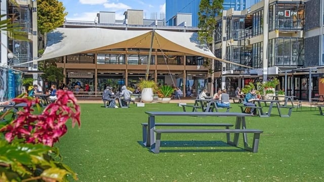 Campus store building with people dining outside exterior at UniLodge Auckland Central in Auckland Student Accommodation