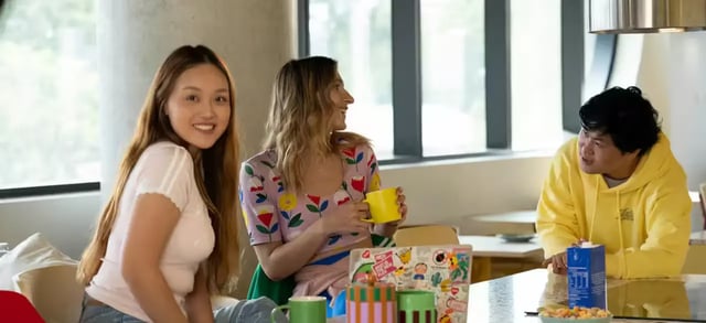 Three people talking at table with mugs living room at Scape Lachlan in Sydney Student Accommodation