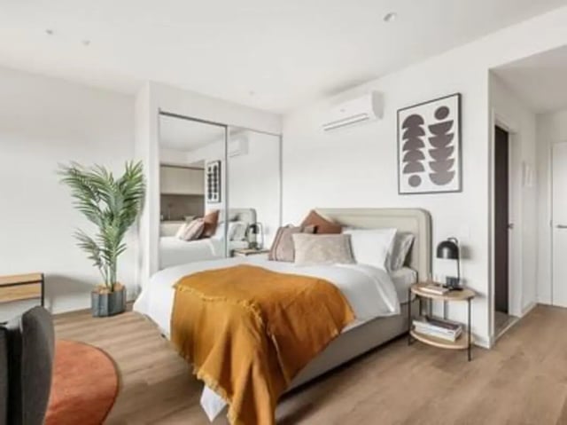 Bed with orange throw plant mirrors bedroom at Caulfield Place in Melbourne Student Accommodation
