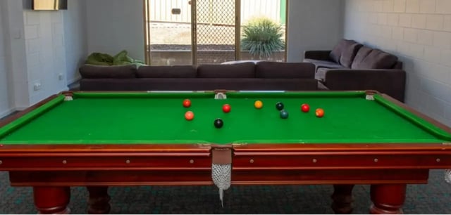 Pool table with balls and couches living room at La Trobe University - Orde House in Melbourne Student Accommodation
