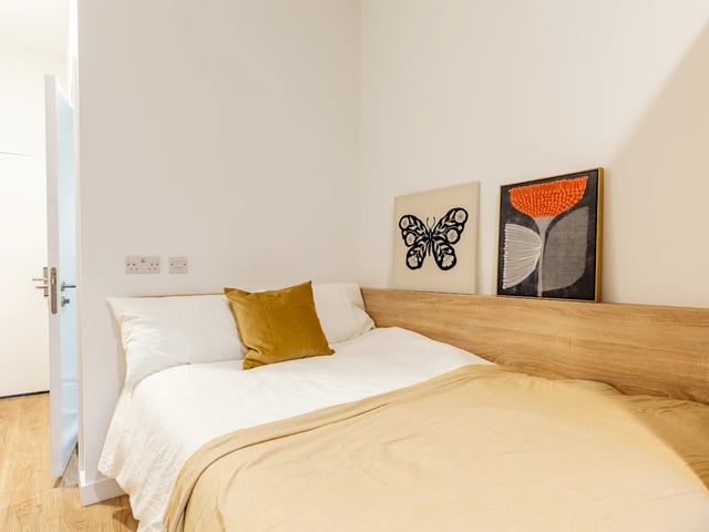 Bed with yellow pillow art above bedroom at Beckton House in Nottingham Student Accommodation