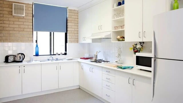 White cabinets kettle microwave and refrigerator kitchen at UniLodge SCU Coffs Harbour in Coffs Harbour Student Accommodation