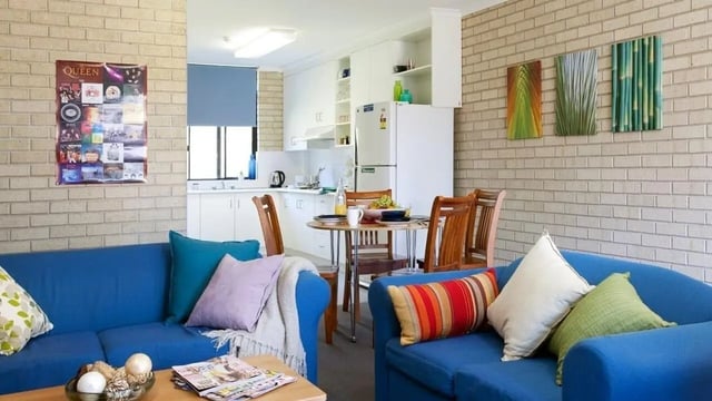 Blue sofas dining table kitchen living room at UniLodge SCU Coffs Harbour in Coffs Harbour Student Accommodation