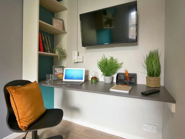 Desk with laptop plants and TV study area at Emily Davies in Southampton Student Accommodation