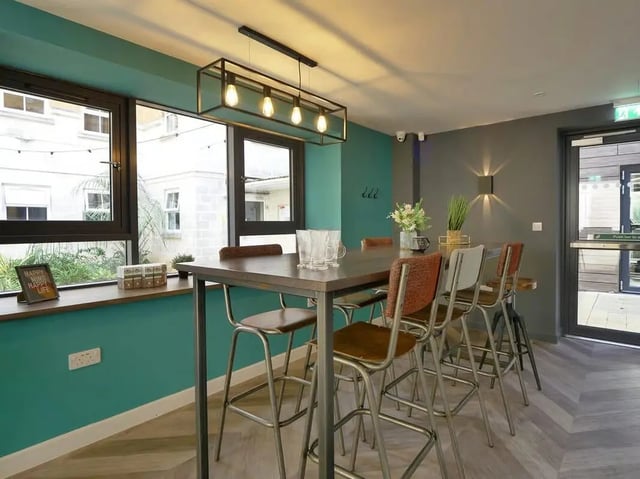 Dining table with bar stools and glasses communal area at Emily Davies in Southampton Student Accommodation