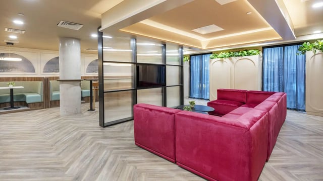 Red sectional sofa TV partition booth seating living room at The Sail Works in Lancaster Student Accommodation