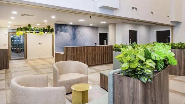 Reception area with chairs plants and doors interior at The Sail Works in Lancaster Student Accommodation