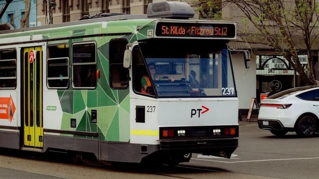 Green tram with driver and destination display exterior at The Archive - Residential Living in Melbourne Student Accommodation