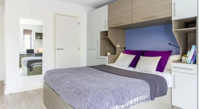 Bed with purple pillows storage and mirror bedroom at St Giles Studios in Durham Student Accommodation