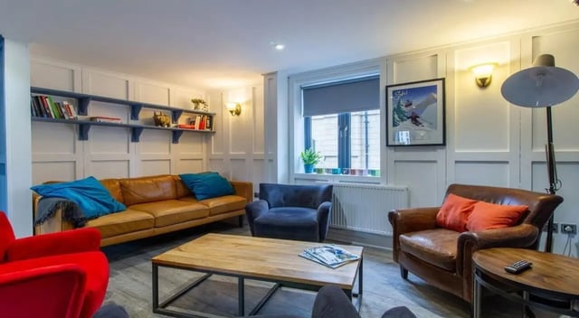 Brown sofa blue cushions coffee table living room at St Giles Studios in Durham Student Accommodation
