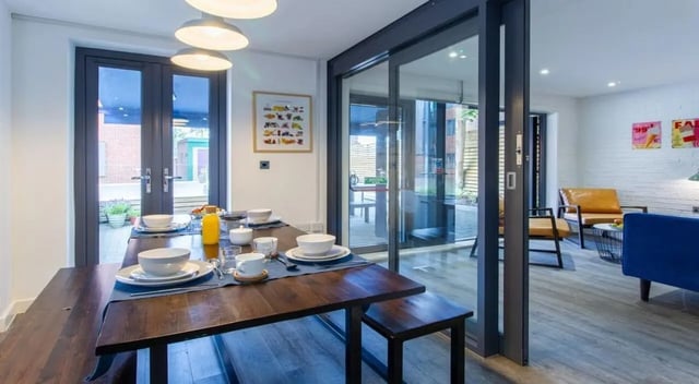 Dining table with place settings and seating area living room at St Giles Studios in Durham Student Accommodation