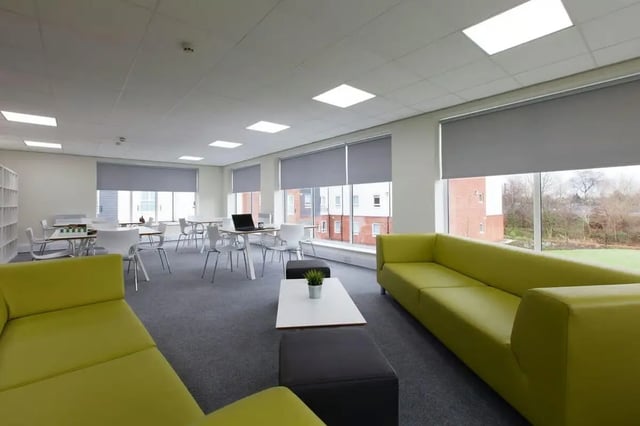 Green couches tables chairs and laptop lounge area at Selly Oak Court in Birmingham Student Accommodation