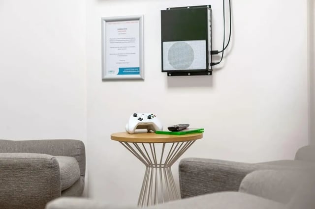 Gaming console controller and remote on table lounge. at Hollingbury House in Brighton Student Accommodation