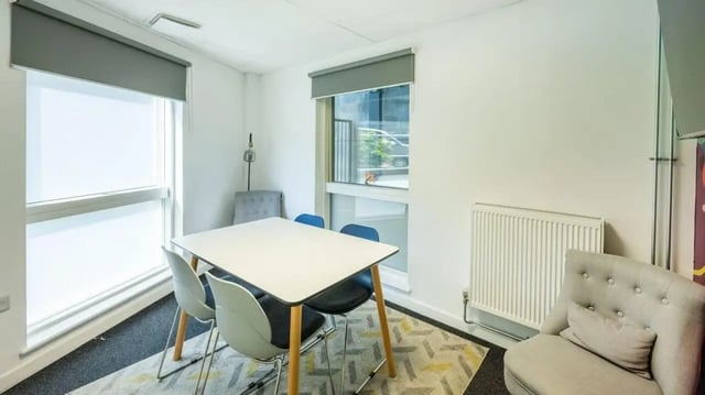 White table four chairs rug and armchair common area at Hollingbury House in Brighton Student Accommodation