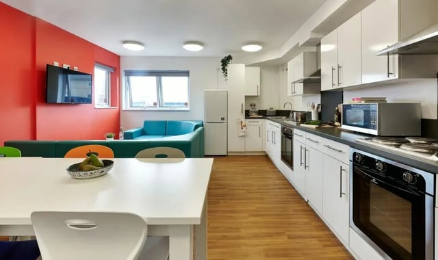 White table blue sofa kitchen living area at Frobisher House in Plymouth Student Accommodation