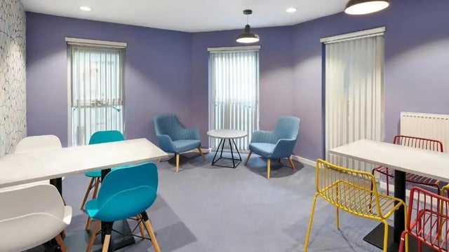 Two tables blue chairs yellow chairs shared space at Frobisher House in Plymouth Student Accommodation
