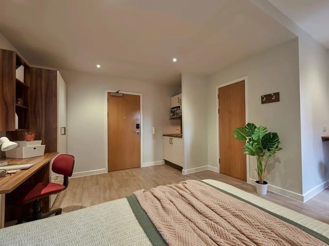Desk chair shelving kitchen unit and bed bedroom at Central Studios Reading in Reading Student Accommodation