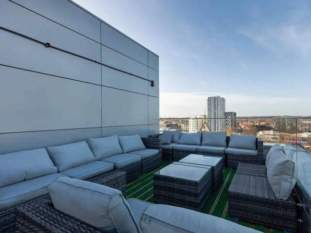 Gray modular sofas with glass top tables exterior at Central Studios Reading in Reading Student Accommodation