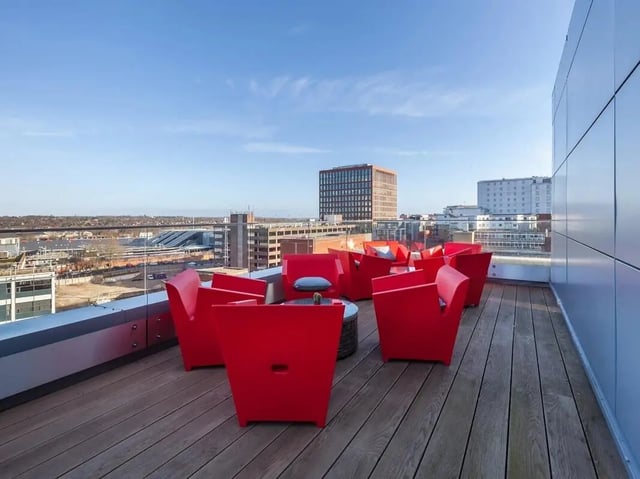 Red chairs and tables on wooden deck exterior at Central Studios Reading in Reading Student Accommodation