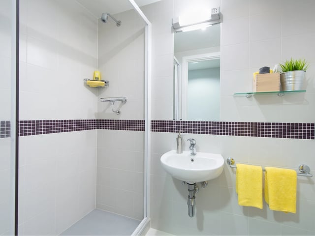 Shower sink towels and mirror bathroom at Glassyard Building in London Student Accommodation