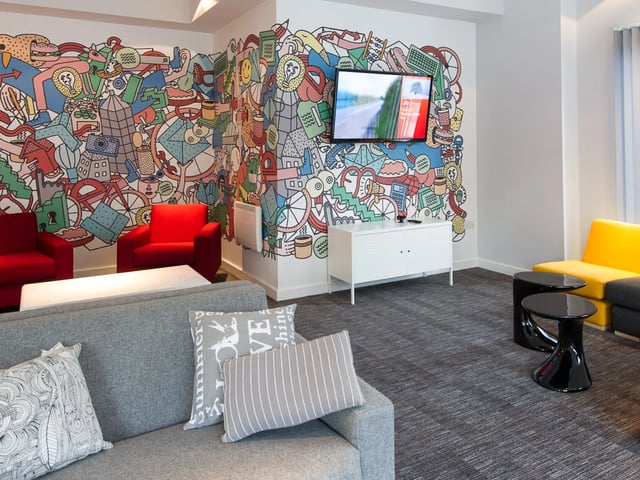 Colorful mural sofas and TV living room at Glassyard Building in London Student Accommodation