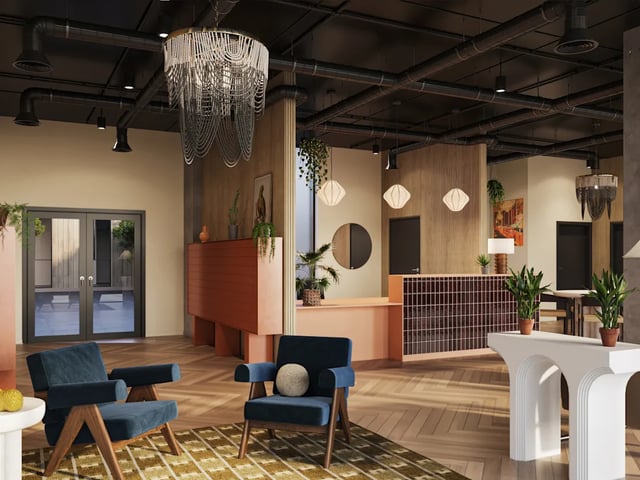 Two blue armchairs check-in desk plants living area at Biscuit Factory in Belfast Student Accommodation