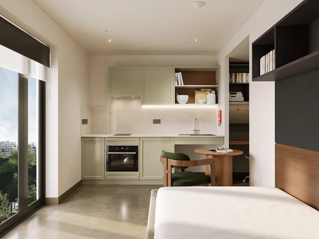 Studio apartment kitchen with stove and dining table at Biscuit Factory in Belfast Student Accommodation