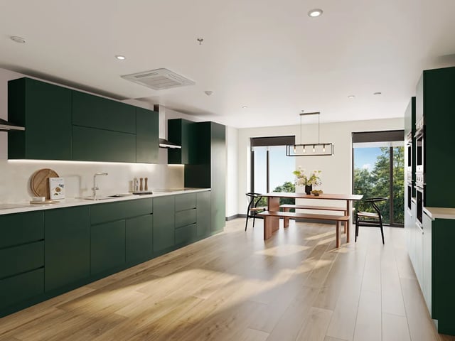 Dark green cabinets dining table bench chairs kitchen at Biscuit Factory in Belfast Student Accommodation